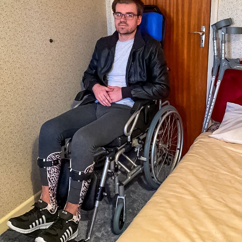 Man in wheelchair with AFO braces and crutches b